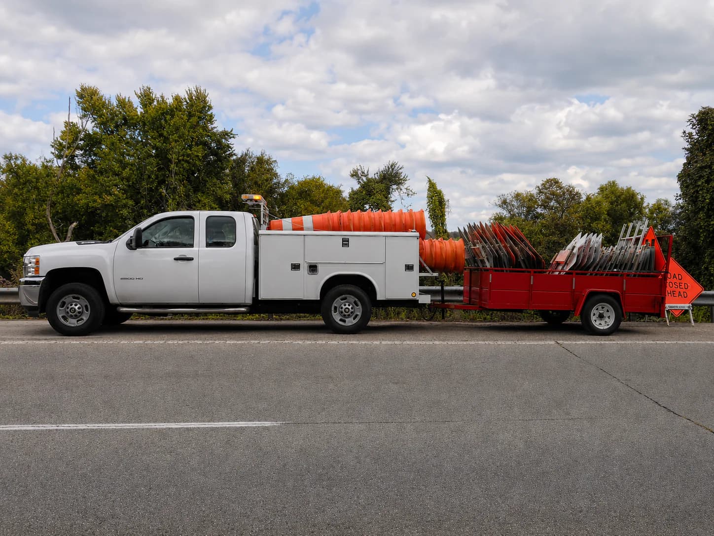 The A-1 Barricades service truck and trailer loaded with drums and barricades